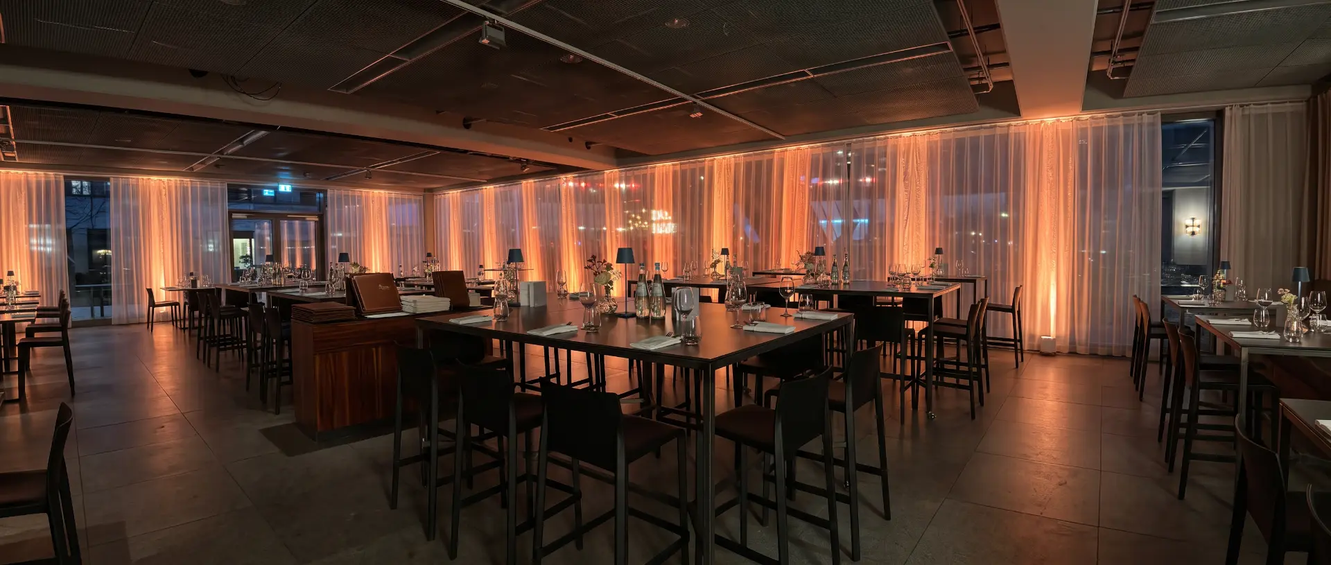 Warm, candlelit event space set up for a conversation with an audience